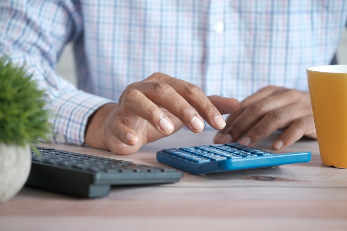 main utilisant une calculatrice à un bureau