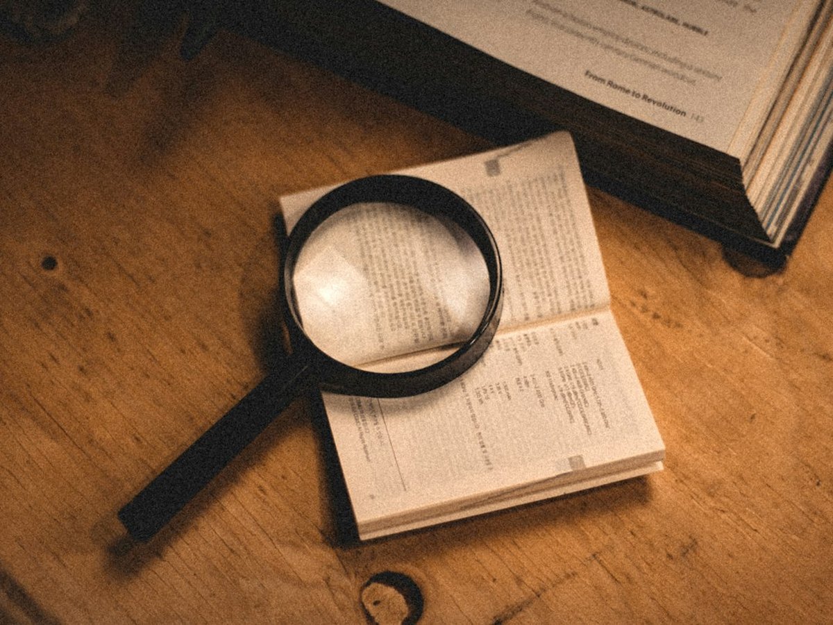 loupe posée sur un livre ouvert : métaphore de l'examen attentif du greenwashing
