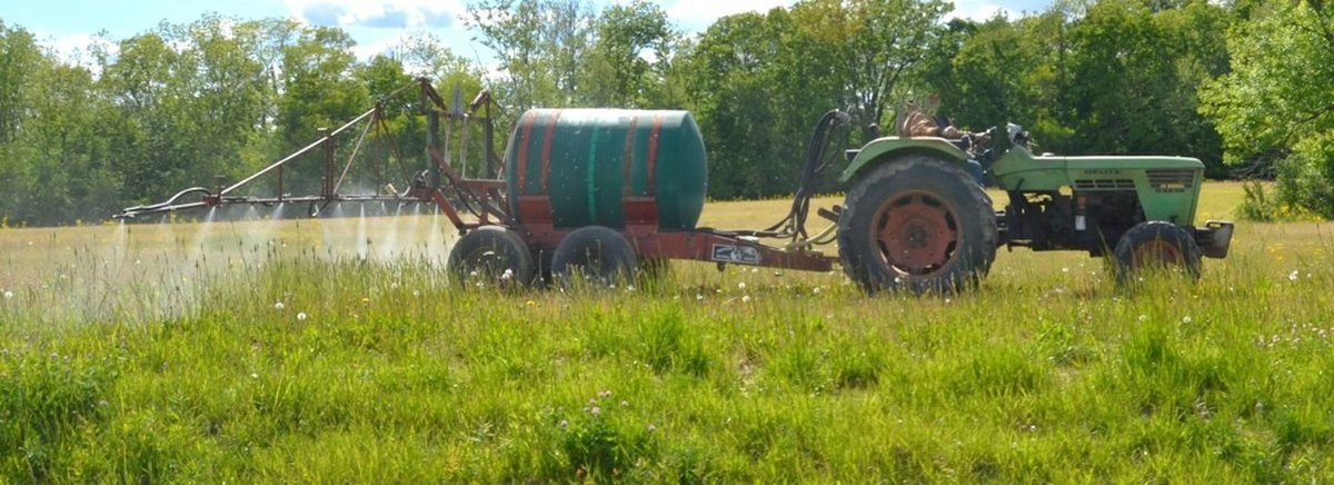 tracteur avec rampe de pulvérisation dans un champ
