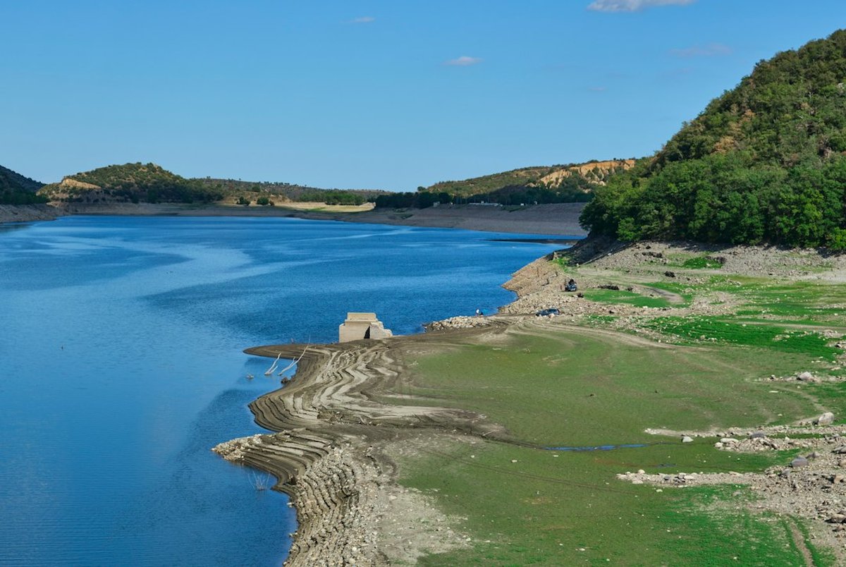 réservoir avec niveau d'eau bas entouré de collines vertes