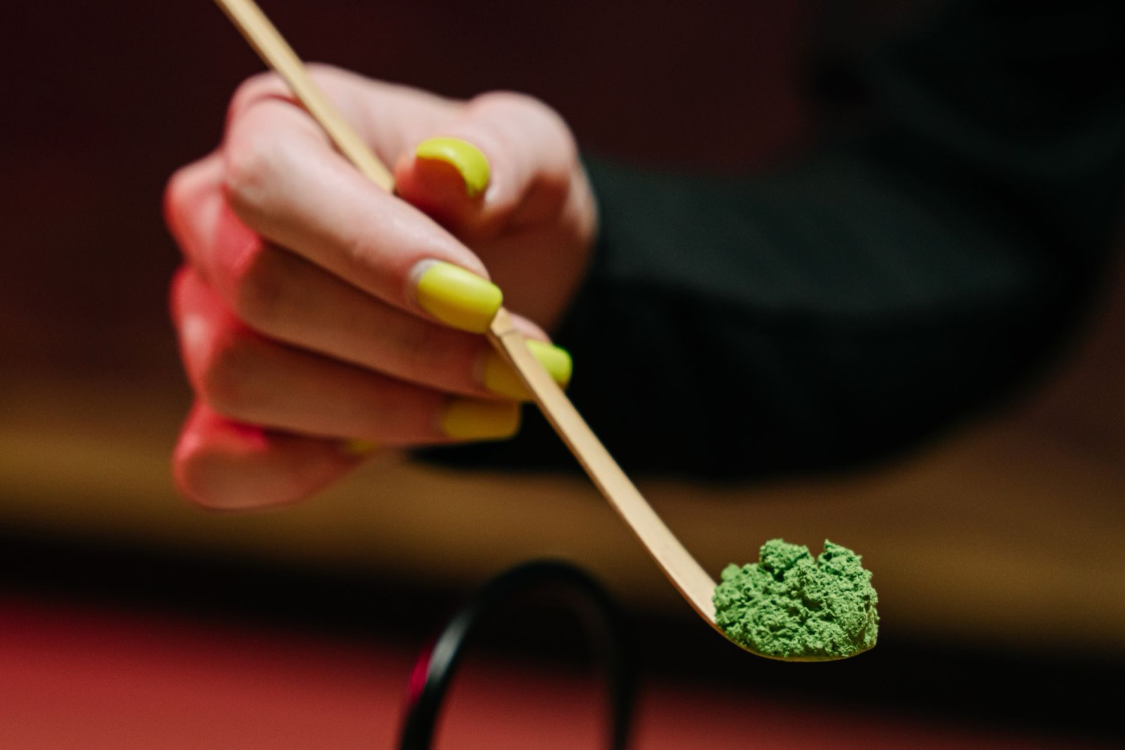 Cuillère de poudre de thé et feuilles séchées, base d'une boisson glacée maison