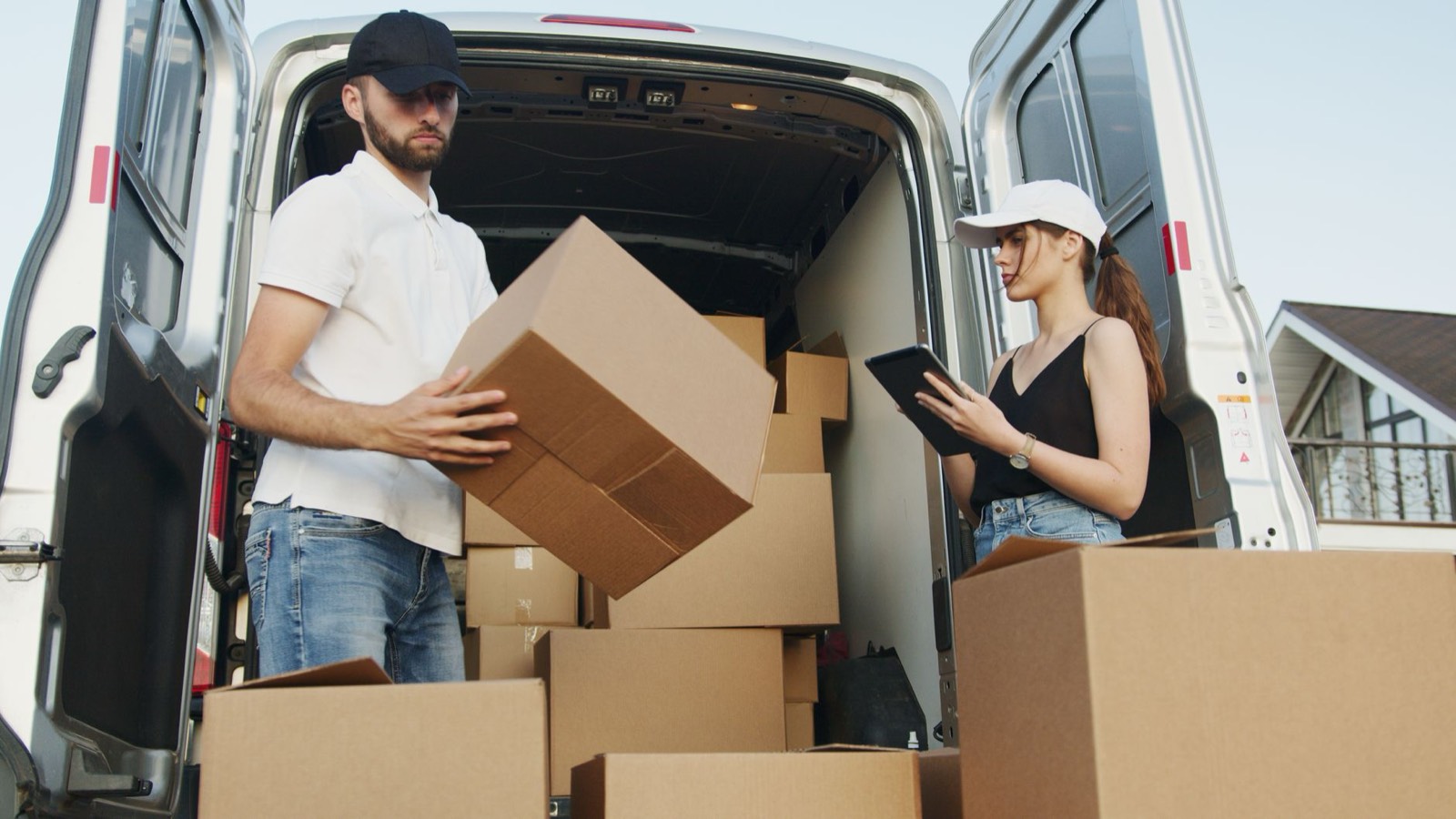 Artisan plombier remplissant ses papiers sur une tablette à côté de sa camionnette